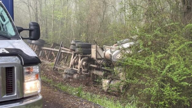 To Avoid Colliding With a School Bus Full of Students, the Log Truck Driver Took the Ditch.